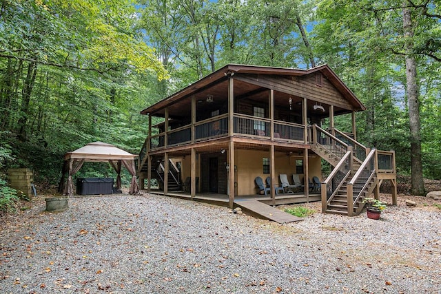 rear view of property featuring a gazebo and a deck