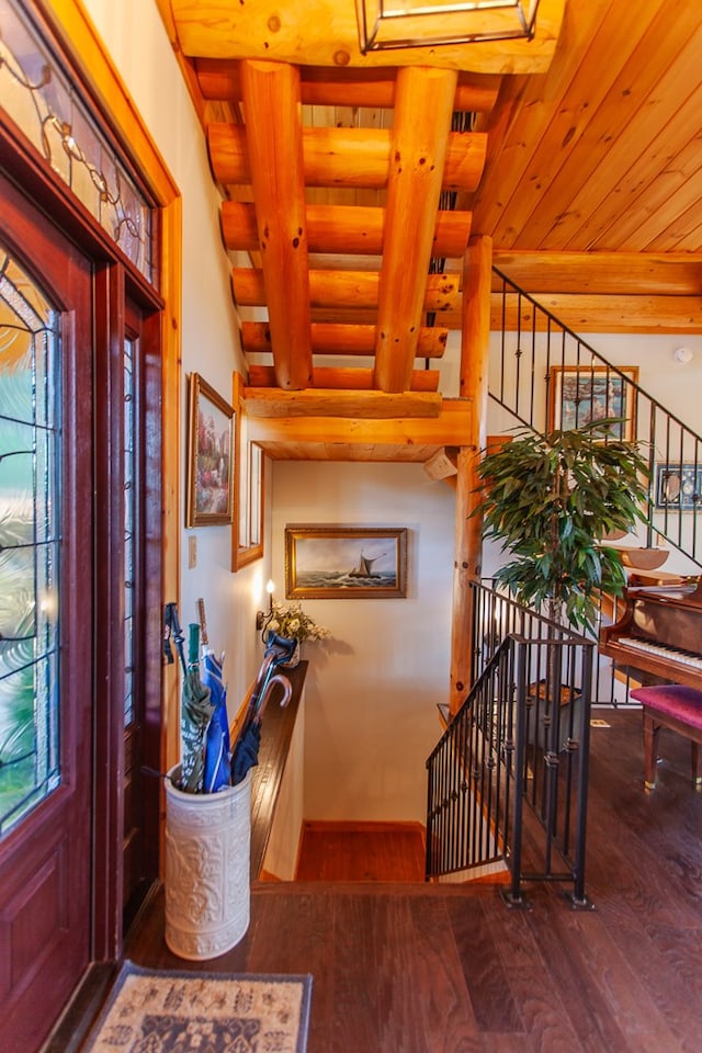 entryway with rustic walls, wooden ceiling, beamed ceiling, and wood-type flooring