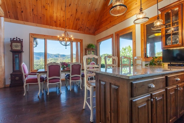 kitchen with dark wood-type flooring, vaulted ceiling, a healthy amount of sunlight, and a notable chandelier