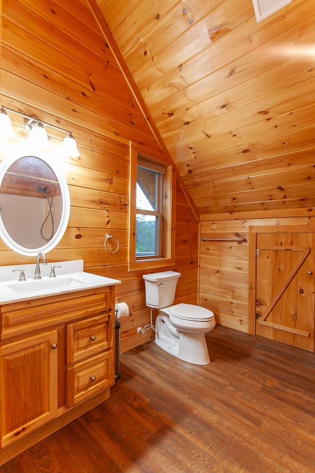 bathroom with wood-type flooring, toilet, lofted ceiling, and wood walls