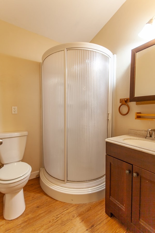 bathroom with vanity, hardwood / wood-style flooring, toilet, and a shower with shower door