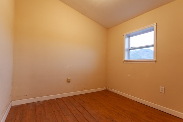 unfurnished room featuring wood-type flooring and vaulted ceiling