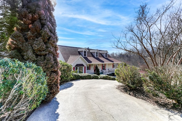 cape cod-style house featuring covered porch