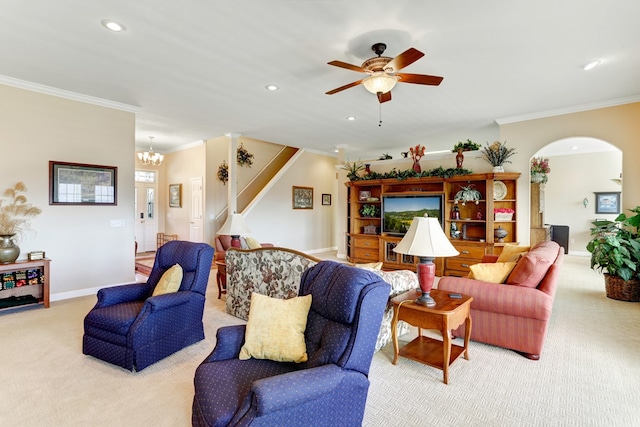 carpeted living room with ceiling fan with notable chandelier and crown molding