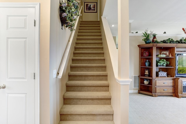 stairway featuring light carpet and crown molding