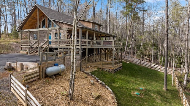 back of house with a wooden deck and a yard