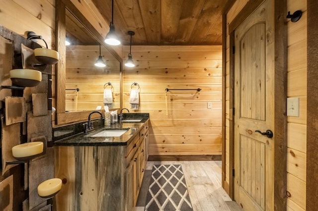 bar with wooden walls, pendant lighting, light hardwood / wood-style flooring, and wooden ceiling