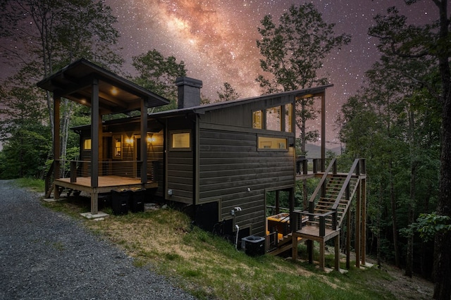 exterior space featuring a wooden deck, stairs, and a chimney