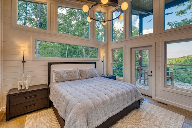 bedroom featuring multiple windows, visible vents, access to exterior, and hardwood / wood-style flooring