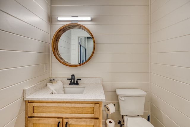 half bath featuring vanity and toilet