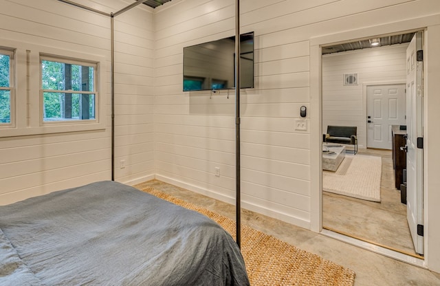 bedroom featuring wood walls