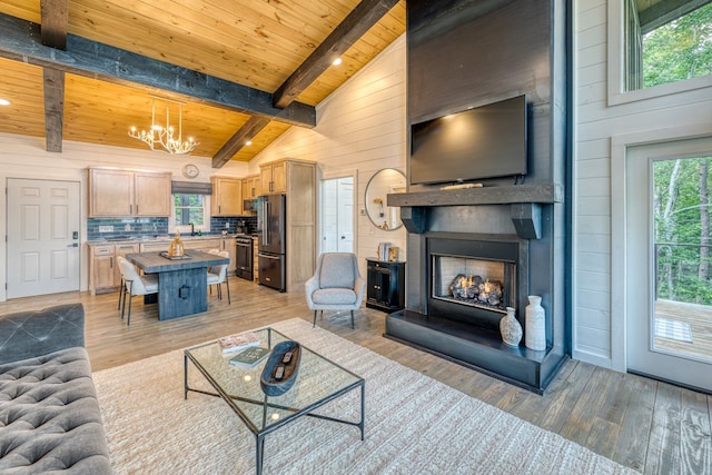 living room with light wood-style floors, wood ceiling, a chandelier, and beamed ceiling