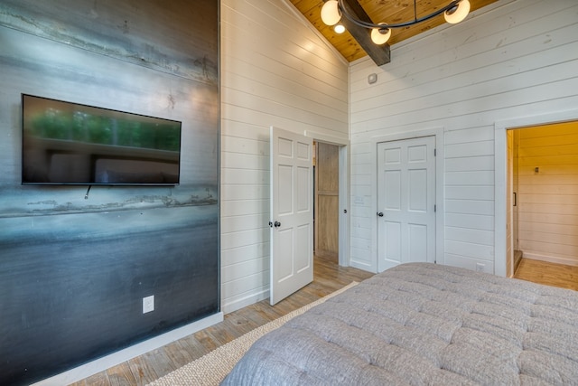 bedroom featuring wood ceiling, ceiling fan, wood walls, wood finished floors, and high vaulted ceiling