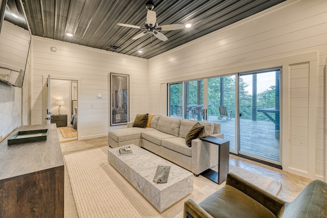 living area featuring recessed lighting, ceiling fan, and wood walls