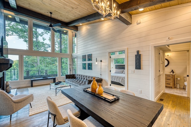 sunroom with a chandelier and beam ceiling