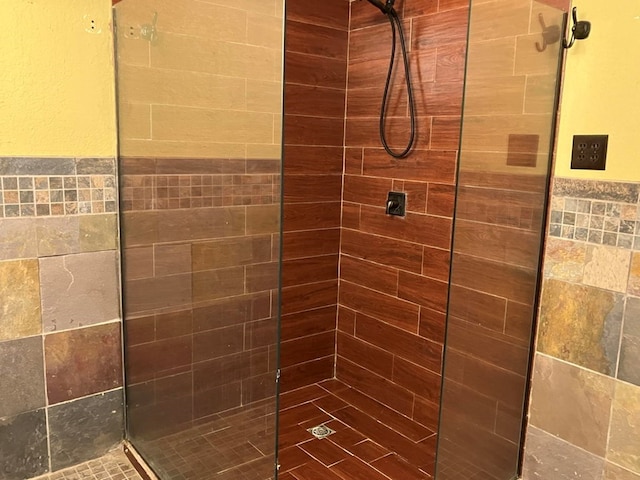 bathroom featuring a tile shower and tile walls