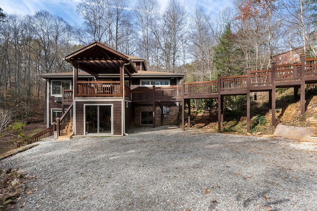 rear view of house featuring a wooden deck