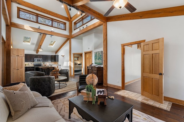 living room with high vaulted ceiling, track lighting, ceiling fan, beamed ceiling, and light hardwood / wood-style floors