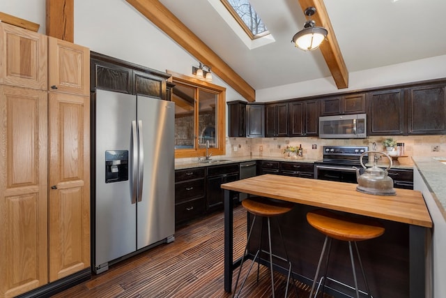 kitchen featuring wooden counters, appliances with stainless steel finishes, decorative backsplash, and lofted ceiling with skylight