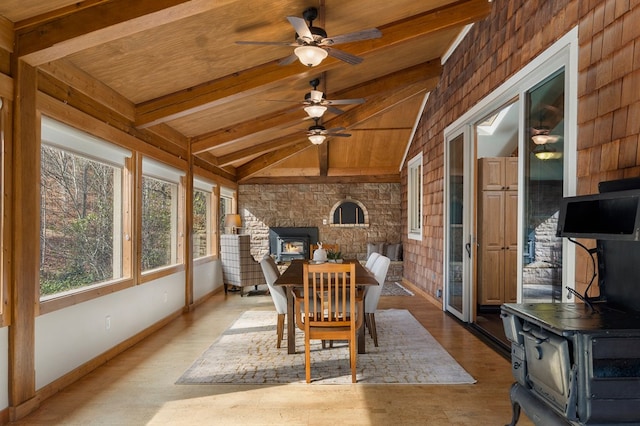 sunroom / solarium featuring lofted ceiling with beams, a wood stove, and wood ceiling