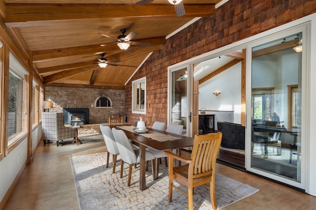 sunroom featuring vaulted ceiling with beams, a wood stove, ceiling fan, and wooden ceiling