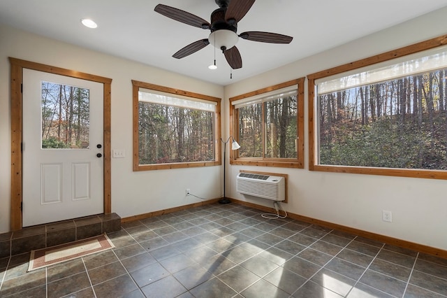 unfurnished sunroom featuring an AC wall unit and ceiling fan