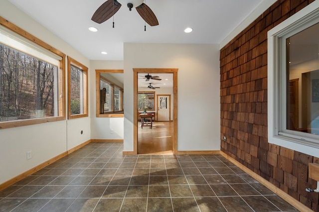 interior space with ceiling fan, plenty of natural light, and dark tile patterned flooring