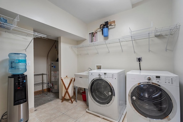 clothes washing area with gas water heater, light tile patterned floors, and separate washer and dryer