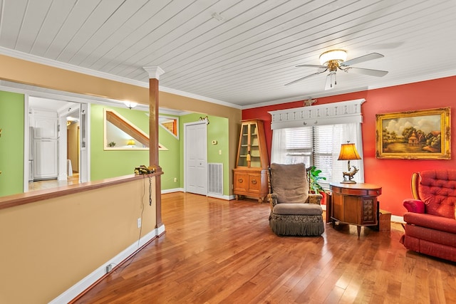 living area with wooden ceiling, hardwood / wood-style flooring, ceiling fan, and ornamental molding