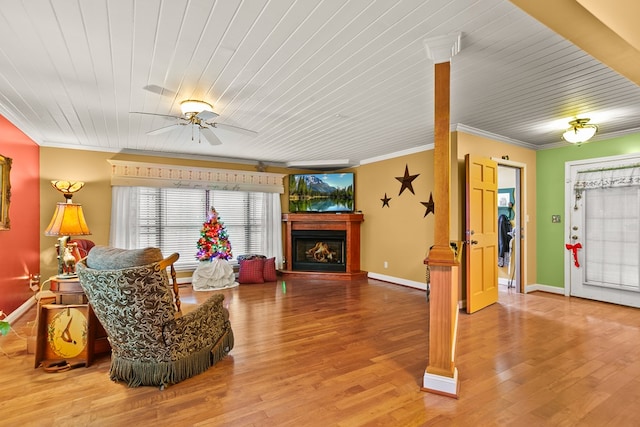 living room with hardwood / wood-style flooring, ceiling fan, and ornamental molding