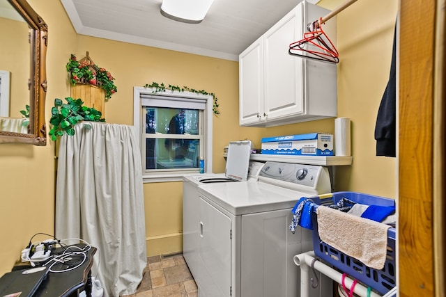 laundry room featuring washer and dryer, crown molding, and cabinets