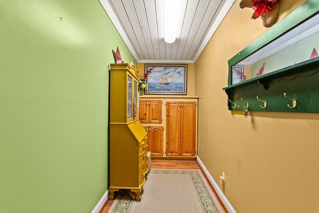 hall with wooden ceiling, crown molding, and light hardwood / wood-style flooring