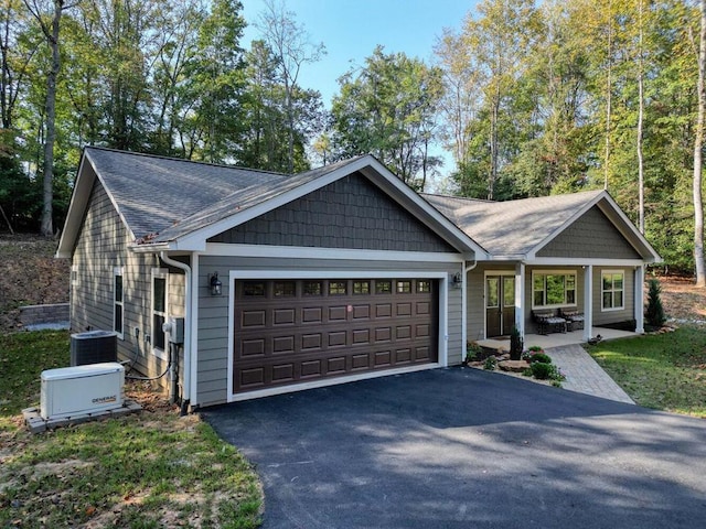 craftsman inspired home featuring central AC unit and a garage