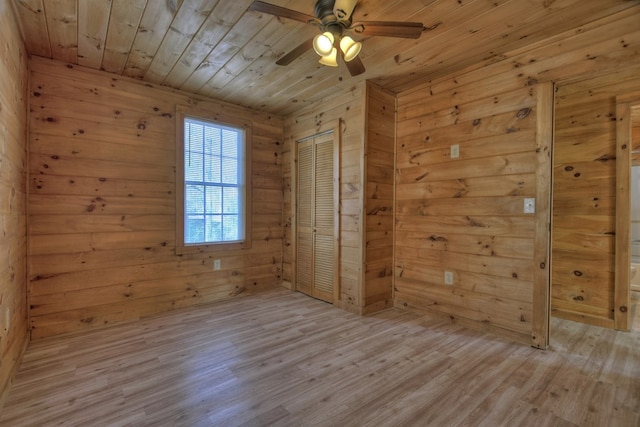 unfurnished room featuring wooden ceiling, ceiling fan, light hardwood / wood-style floors, and wood walls