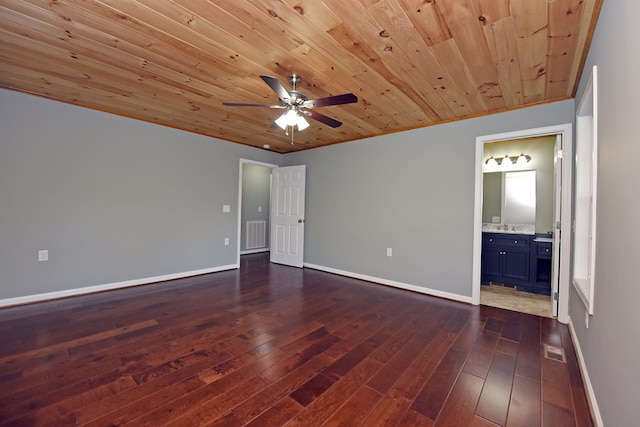 unfurnished bedroom with dark wood-type flooring, wooden ceiling, ceiling fan, and ensuite bathroom