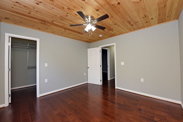 unfurnished bedroom featuring dark hardwood / wood-style flooring, wood ceiling, and a spacious closet