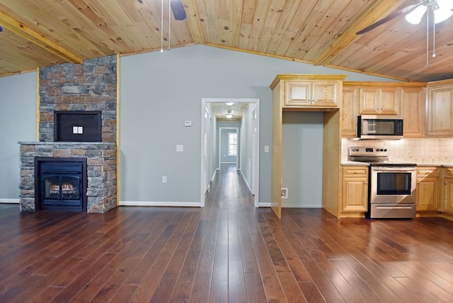 kitchen featuring ceiling fan, appliances with stainless steel finishes, dark hardwood / wood-style flooring, and vaulted ceiling