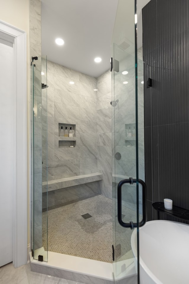 bathroom featuring recessed lighting, a freestanding bath, and a stall shower
