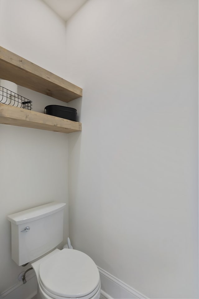 bathroom featuring toilet and baseboards