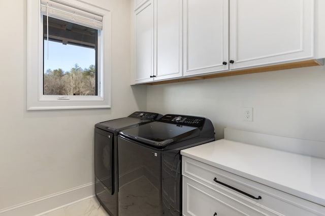 laundry area featuring washer and clothes dryer, cabinet space, marble finish floor, and baseboards