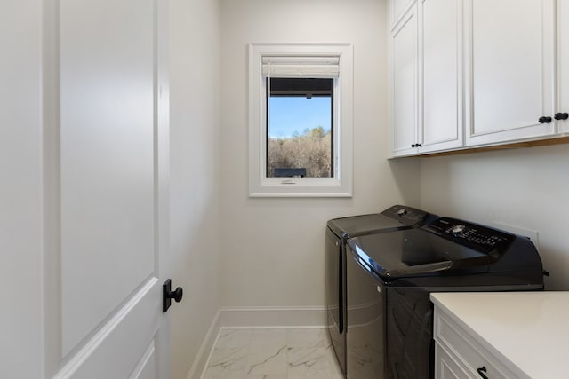 laundry room with baseboards, cabinet space, marble finish floor, and washer and clothes dryer