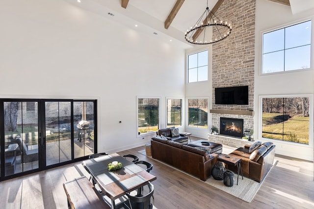 living room featuring a chandelier, beam ceiling, high vaulted ceiling, and wood finished floors