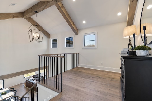 hallway with wood finished floors, visible vents, baseboards, lofted ceiling with beams, and a notable chandelier