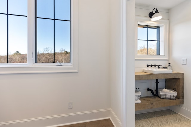 bathroom with a wealth of natural light, baseboards, and a sink