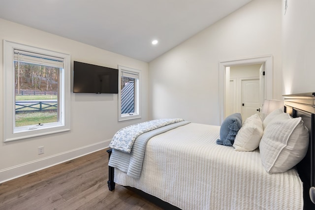 bedroom with lofted ceiling, recessed lighting, wood finished floors, and baseboards