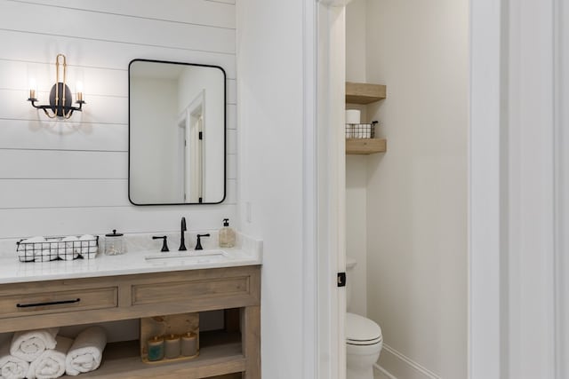 bathroom featuring baseboards, toilet, and vanity