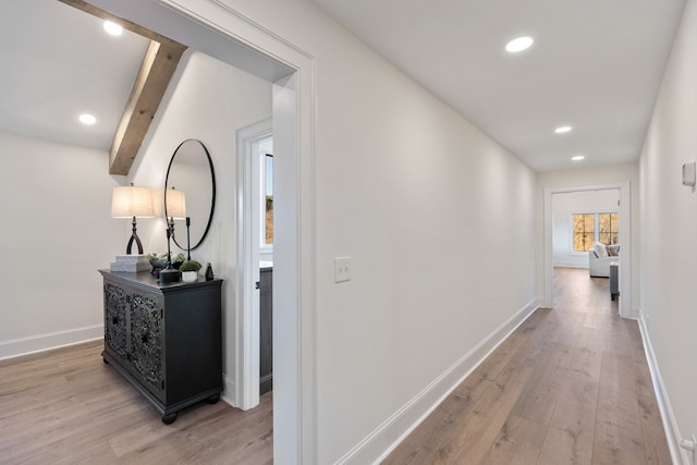 hall with recessed lighting, baseboards, beam ceiling, and light wood-style flooring