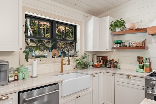 kitchen featuring appliances with stainless steel finishes, vaulted ceiling, and white cabinets