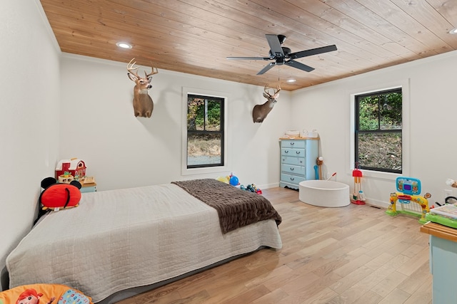 bedroom featuring light hardwood / wood-style flooring, multiple windows, and wood ceiling