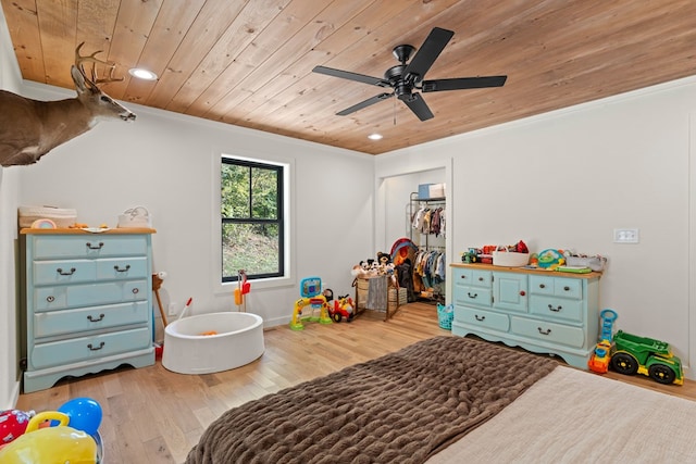 bedroom featuring hardwood / wood-style flooring, a closet, wooden ceiling, crown molding, and ceiling fan